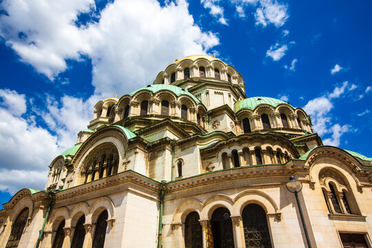 Low angle panoramic view of the majestic St Alexander Nevsky Cathedral under a dramatic cloudy blue sky in Sofia, Bulgaria