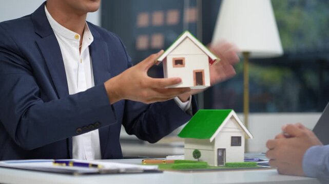 home loan officer uses a calculator with a house plan loan real estate or property.
