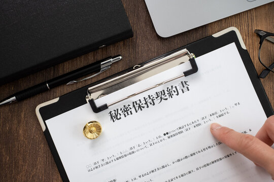 秘密保持契約書を確認する男性の手元