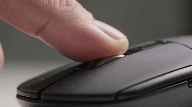 Close-up of finger scrolling on computer mouse wheel, digital navigation, online browsing
