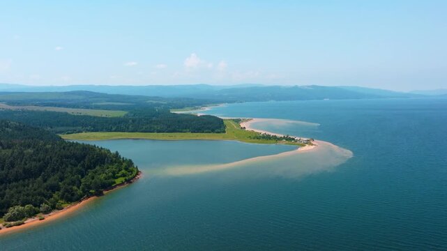High altitude aerial view Shiroka Polyana water reservoir shore sandy cape pine tree woods green fields blue sky horizon line summer vacation travel Bulgaria