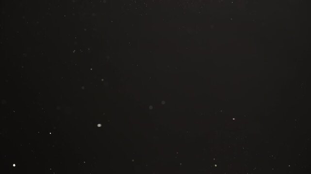 Slow motion real dust flow over dark background