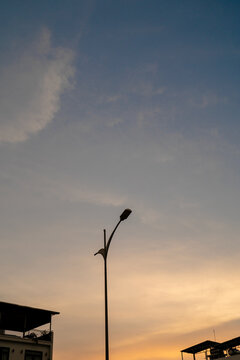 Silhouette of a street lamp against a colorful sunset sky.