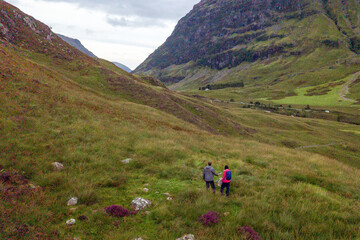 Obraz premium Hikers explore lush valley landscape.
