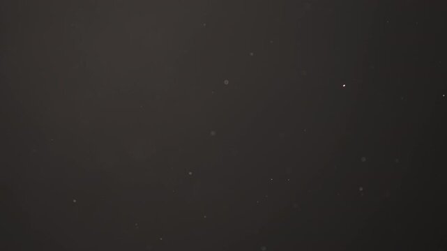 Slow motion real dust flow over dark background