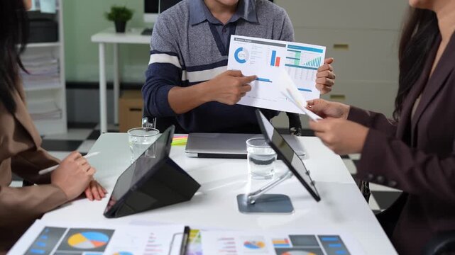 Business consultants discuss tax, merger strategy and restructuring in modern office.