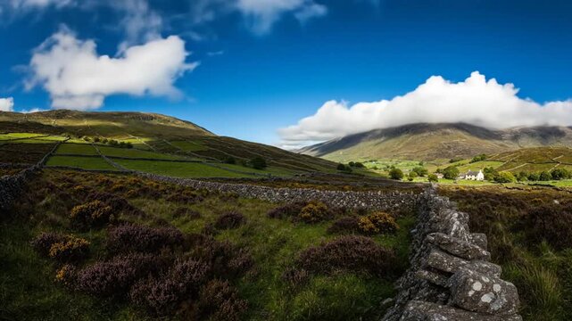 Scenic aerial view of rolling green hills, stone walls, and a fluffy cloud-filled sky over a peaceful rural landscape