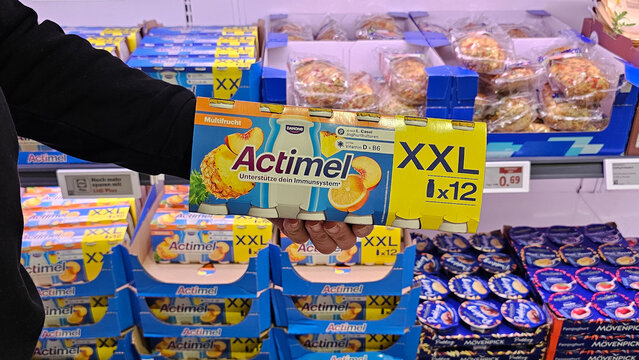 Hand holding actimel yogurt drink xxl pack in supermarket