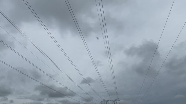 High voltage power lines. Helicoper inspecting the functionallity with electricity distribution and pylons.