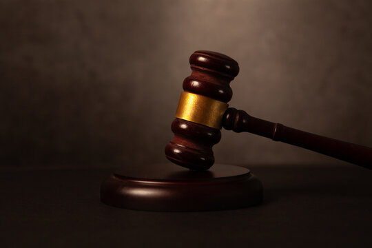 Law theme, mallet of judge, wooden gavel on brown background