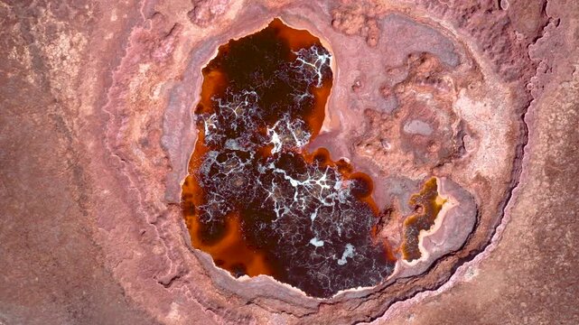 An aerial view of vivid red and yellow acid pools surrounded by mineral deposits in Ethiopia Dallol geothermal region