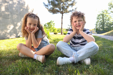 Fototapeta premium Cute little kids spending time together on grass in park