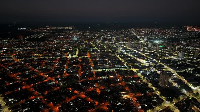 Aerial view of a sprawling city at night with illuminated streets and buildings creating a vibrant urban landscape