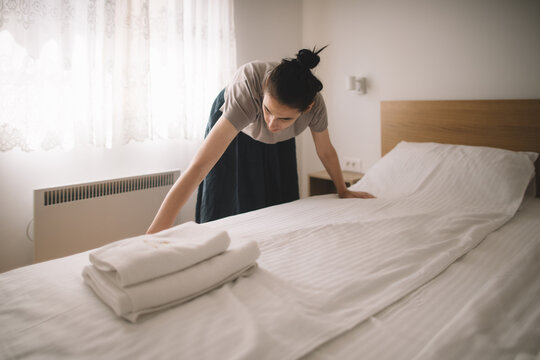 Housekeeper making fresh bed
