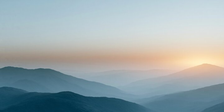 Sunrise over misty layered mountain landscape