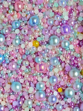 Pastel pearl beads texture background. Colorful mixed plastic beads and rhinestones pattern close-up.