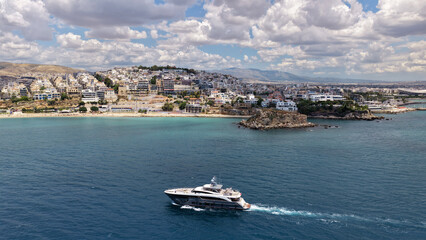 Naklejka premium Aerial drone photo of small yacht cruising in low speed near marina and port of Zea or Pasalimani, Piraeus, Attica, Greece
