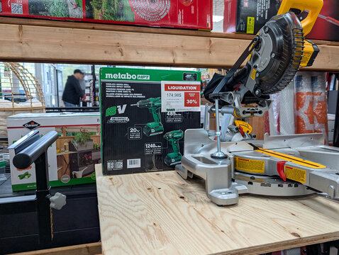 Quebec, Canada, 22 April 2026 : Metabo HPT cordless drill box on liquidation and a DeWalt miter saw displayed in a store.