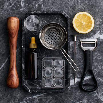Mixology Magic: Bartender Tools and Ingredients for Craft Cocktail Preparation on Black Marble Tabletop