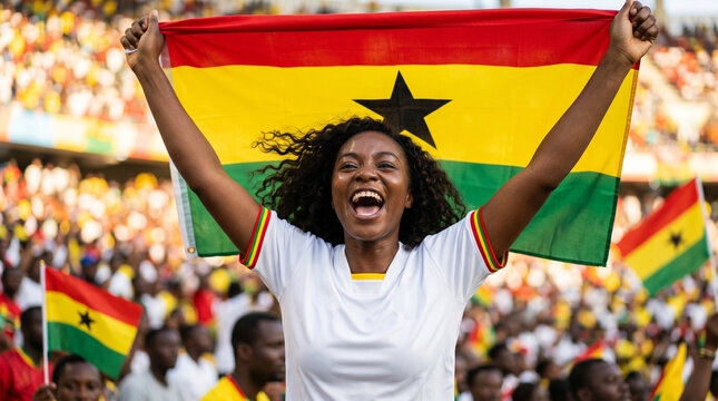 Cheerful Ghanaian football fan celebrating with Ghana flag at stadium