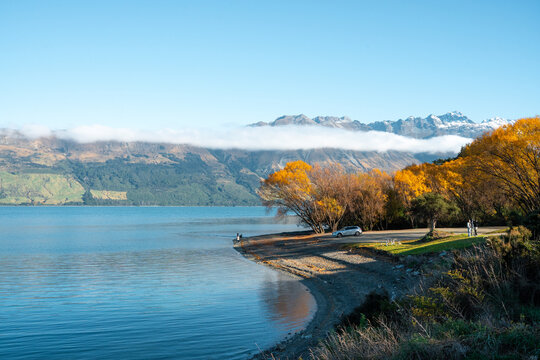 Autumn scenery by the lakeside and the sea of clouds over distant mountains, Lake Wakatipu, New Zealand