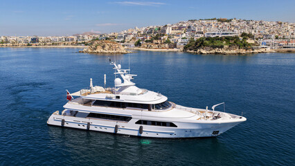 Naklejka premium Aerial drone photo of small yacht cruising in low speed near marina and port of Zea or Pasalimani, Piraeus, Attica, Greece