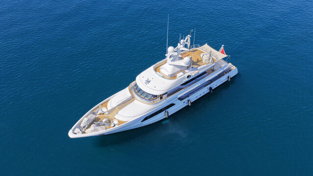 Aerial drone top down photo of luxury yacht with wooden deck anchored in deep blue Aegean Sea