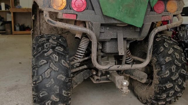 ATV is idling. Four Wheeler Idle Exhaust Fumes. Atvs idling with oversized tires. Power, grip. atv tailpipe blowing vapor underbody muffler surface, exhaust plumes, engine revs creating smoky bursts