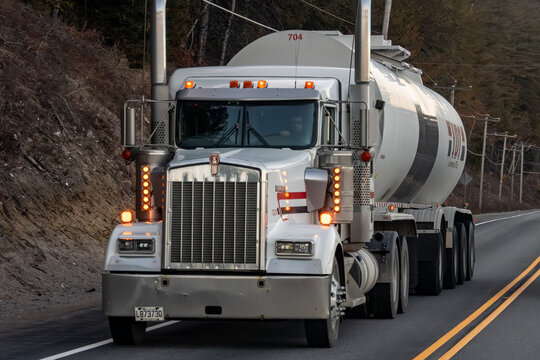 Quebec, Canada, 24 April 2026 : A Kenworth semi-truck with a Ryder tanker trailer drives on a road through a wooded area.