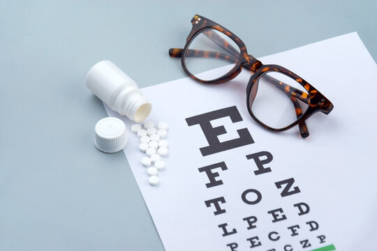 Eye test chart and glasses on blue background