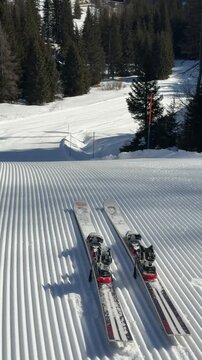 Freshly groomed corduroy snow on a ski slope in the Dolomiti Superski region, Italy. Skis resting on a perfectly prepared piste surrounded by the spectacular Dolomites. Winter sports and alpine advent