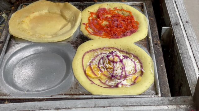 Cooking delicious mini martabak with various savory and sweet toppings