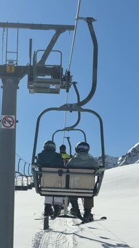 Chairlift with skiers in Livinallongo del Col di Lana, Dolomites, Italy. Alpine winter landscape in the Dolomiti Superski region. Skiing, winter sports and mountain adventure in the Italian Alps