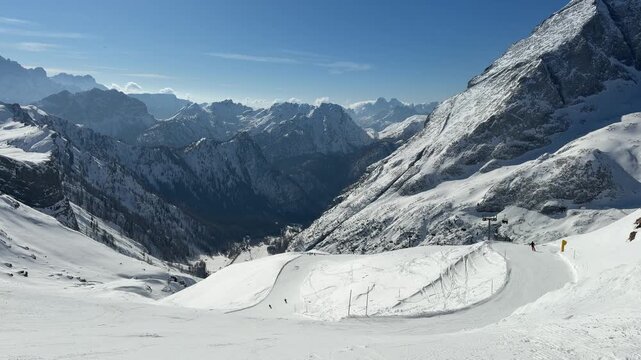 Panoramic ski slope in Rocca Pietore, Dolomites, Italy. Skiers surrounded by spectacular snow-covered peaks and alpine scenery in the Dolomiti Superski region. Winter sports and mountain adventure