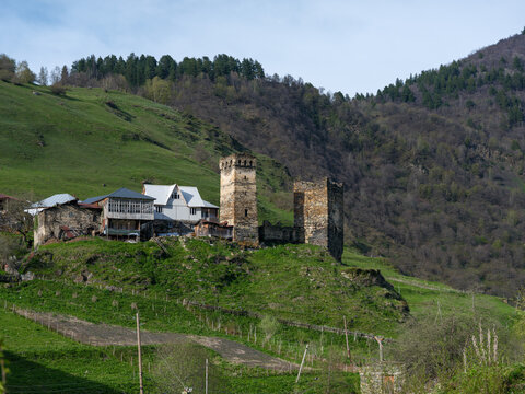 Svaneti historic village with medieval stone towers and blooming spring trees, Georgia.