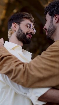 Two men in love, sharing close and joyful embrace, their faces lit with happiness of being together. ender moment between two men in a loving embrace, exchanging a gentle kiss with smiles


