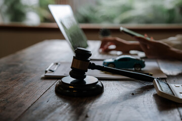 Fototapeta premium A judge’s gavel stands beside a model car and legal documents, symbolizing auto insurance claims, traffic accidents, liability disputes, compensation, and legal justice.