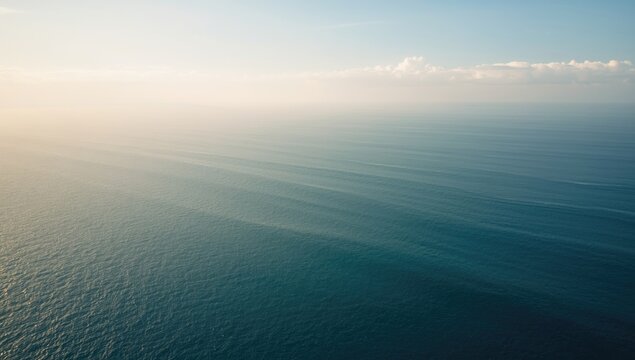 Wide ocean horizon with light cloud cover