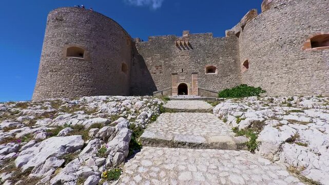 POV walking up the stone path toward the main entrance of Chateau d'If in Marseille, France