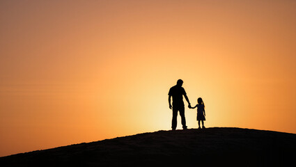 Fototapeta premium Father's Day Concept with Father and Daughter Holding Hands at Sunset