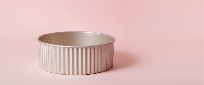 Ribbed base springform cake pan isolated against soft pastel copy space background