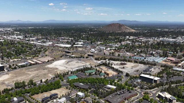 Wide aerial highway 97 through forested high desert town of Bend Oregon in summer