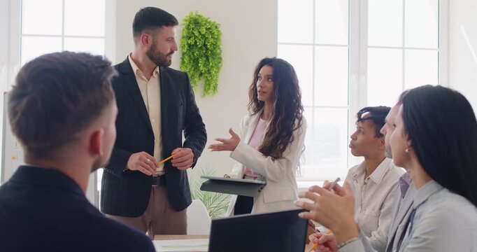 Young woman introducing new company employee for a group of staff applauding on a meeting in modern office. Business people sitting on workplace during job conference. 4k video. Slow motion video