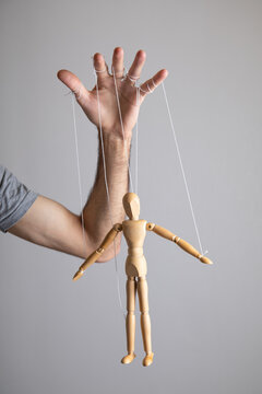Man controls the action wooden marionette.