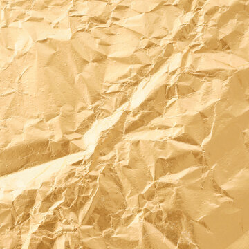 Luxury crumpled gold foil texture surface with natural highlights and shadows from random folds warm metallic sheen premium packaging material champagne tones no people