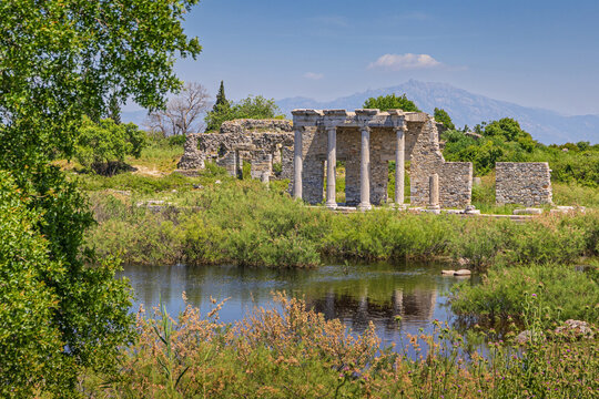 Ancient Greek ruins of the Miletus complex standing by a scenic reflecting pool during daytime
