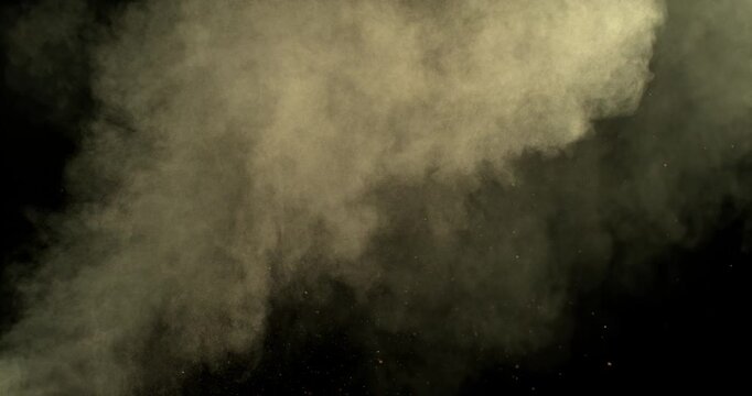 Ultra slow motion dust or sand cloud drifting through the air on a black background. Particle explosion effect ideal for overlays, compositing, visual effects, motion graphics and VFX projects.