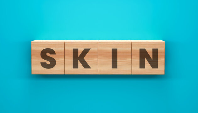 Wooden Blocks Spelling SKI: Four wooden blocks, each with a single letter, are arranged to spell the word SKI against a vibrant blue background.