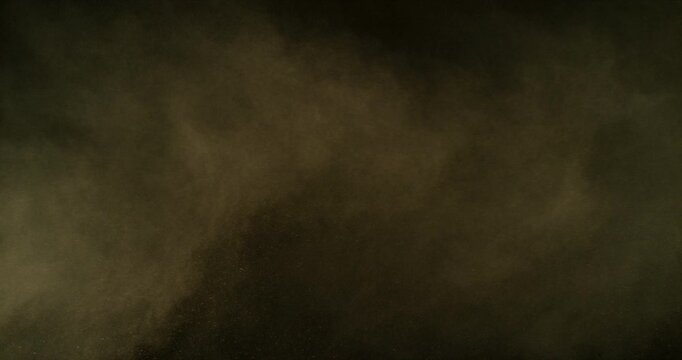 Ultra slow motion dust or sand cloud drifting through the air on a black background. Particle explosion effect ideal for overlays, compositing, visual effects, motion graphics and VFX projects.