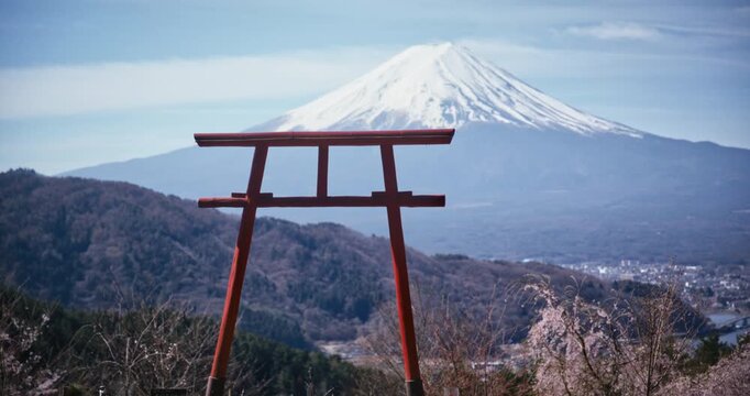 Beautiful torii gate on hill with view of valley and tall Mt. fuji in distance - steady cam shot